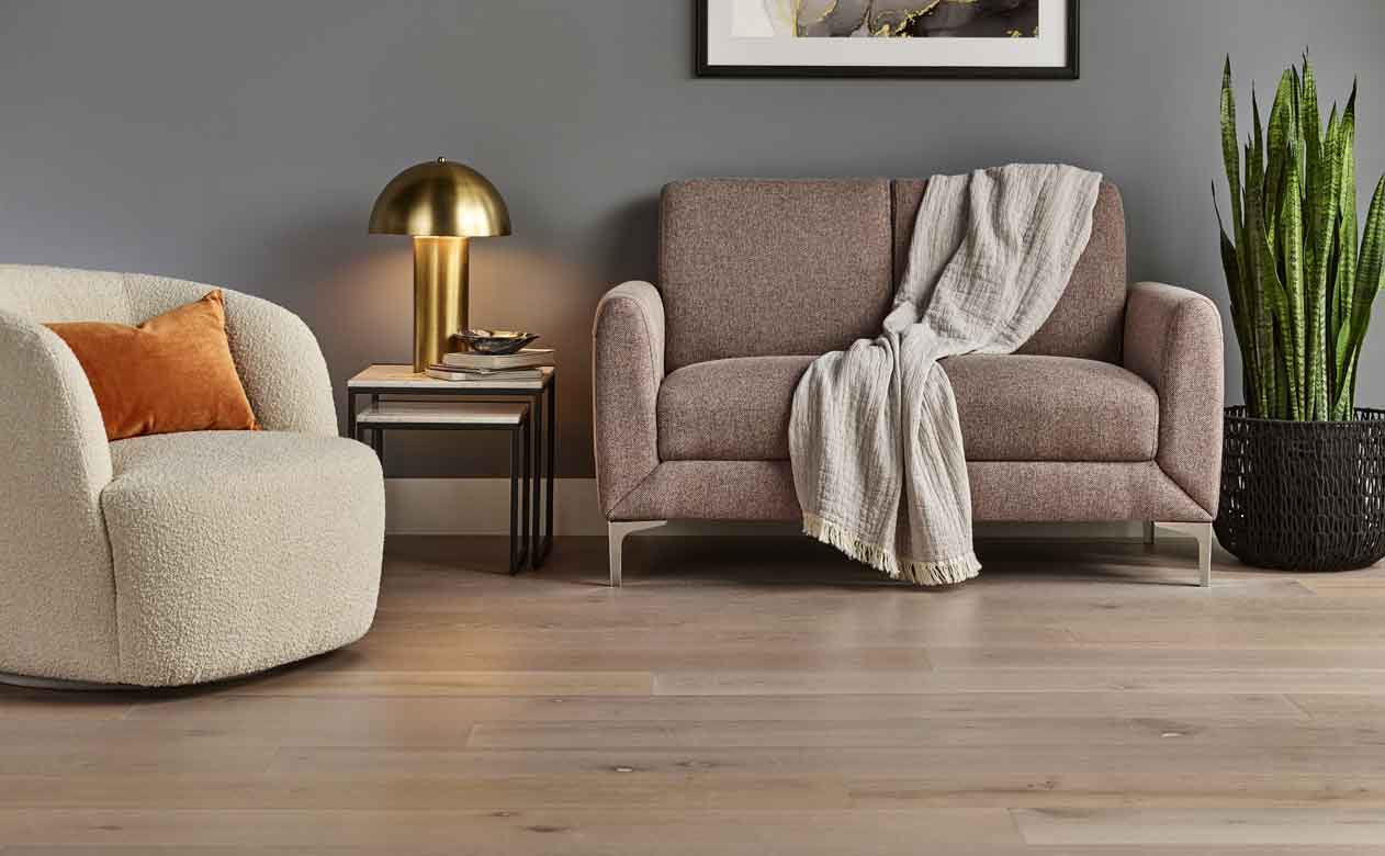 hardwood floors in a living room with a brown loveseat and beige accent chair