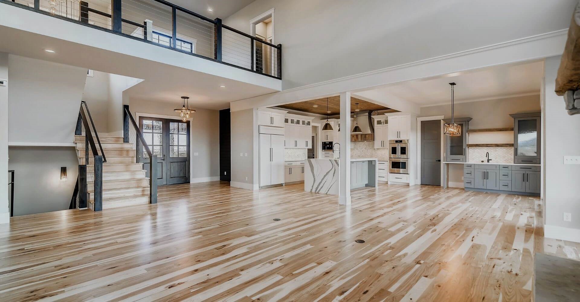 Dad pushing Daughter in Cardboard Box on Hardwood Floors