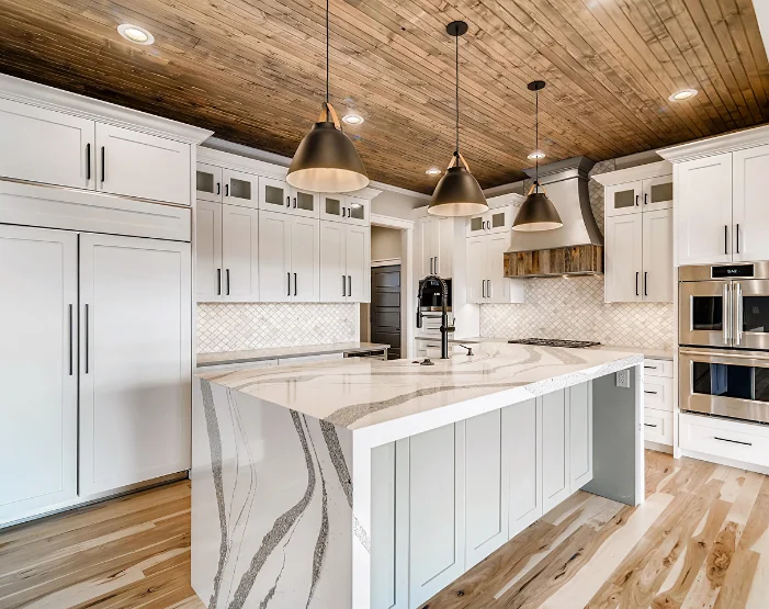 Kitchen with white cabinetry and waterfall countertops from Loveland Design